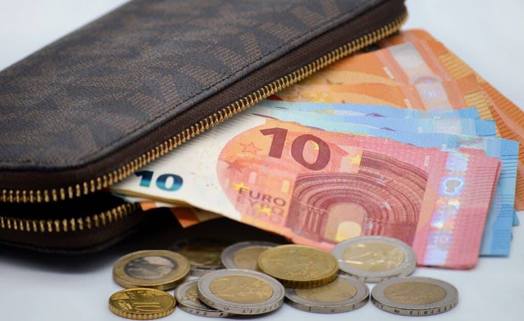 Geldbörse mit mehreren Euro-Scheinen und Münzen als Symbol für Inflation und weniger Geld