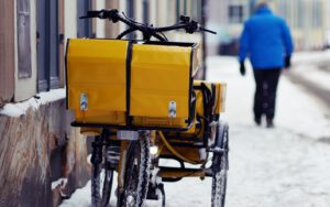 Postwagen der Deutschen Post auf einem verschneiten Weg als Symbol der Postgesetz-Reform