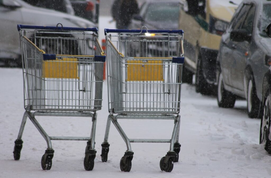 Einkaufswagen auf einer verschneiten Straße als Symbol der geringen Konsumlust zu Jahresbeginn 2024