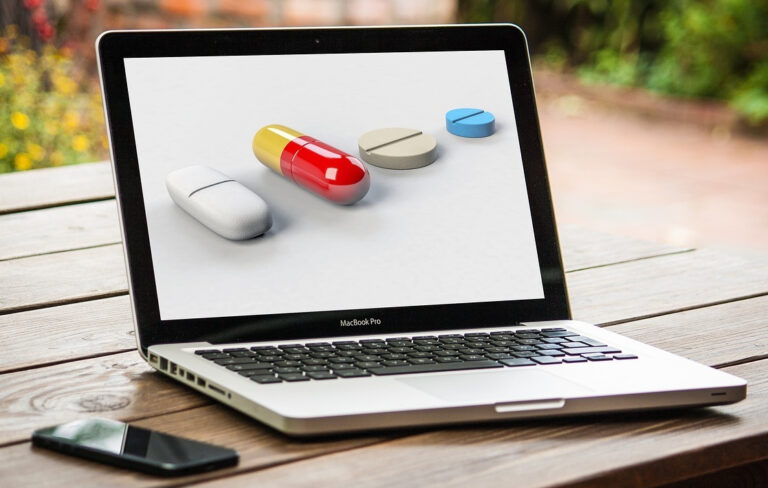 Laptop mit Arzneimittel als Symbol für Online-Apotheken