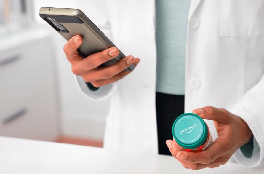 Foto eines Apothekers mit einer Amazon Pharmacy Dose und einem Smartphone