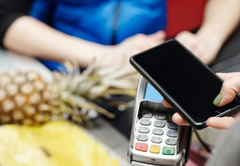 Kunde mit mobiler Bezahlung per Smartphone im Supermarkt