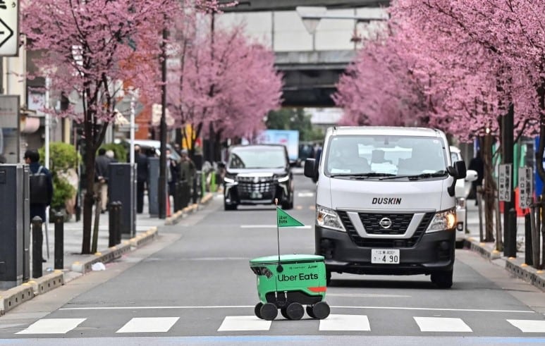 Ueber Eats Roboter der in Tokio einen Zebrastreifen kreuzt