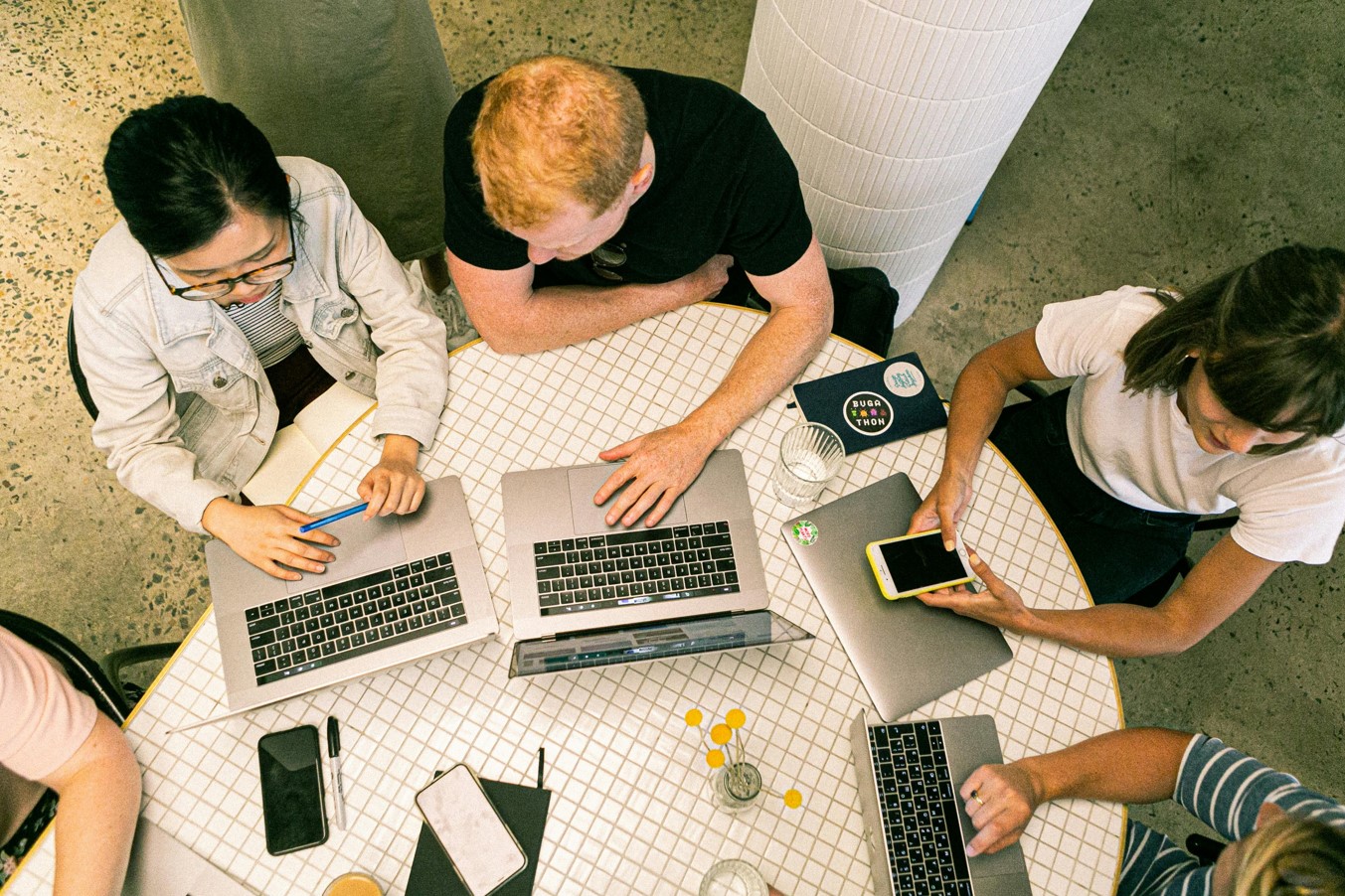 Mehrere Menschen mit Laptops an einem Tisch