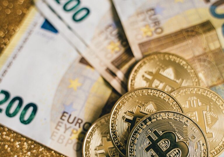 Bitcoin als Münze vor mehreren Euro-Geldscheinen