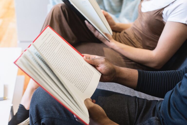 Zwei Menschen mit einem Buch in der Hand beim Lesen