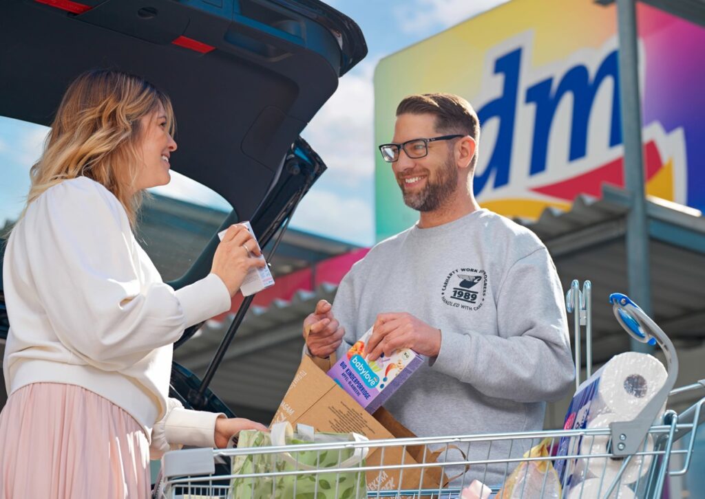 Kunden mit Einkaufswagen vor einem dm Drogerie-Markt