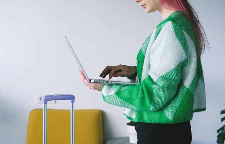 Junge Frau stehend mit Laptop auf dem Arm