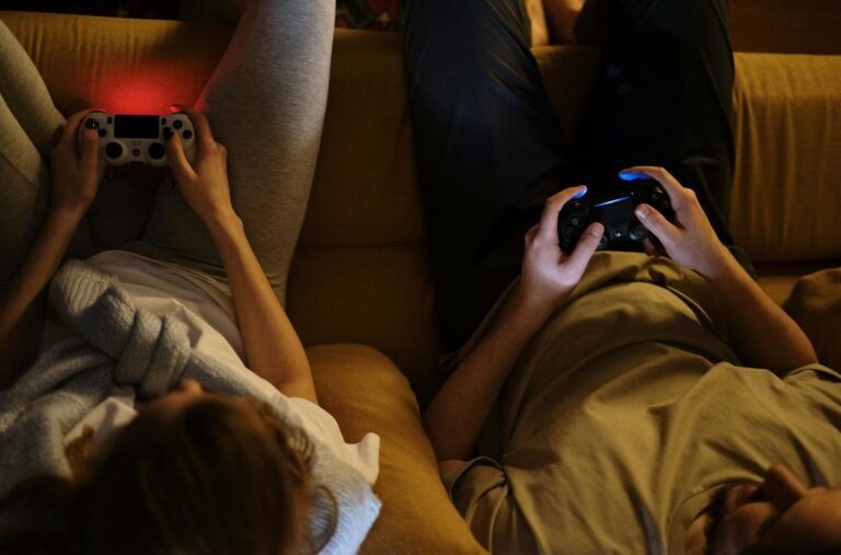 Frau und Mann auf dem Sofa beim mit Playstation-Controller