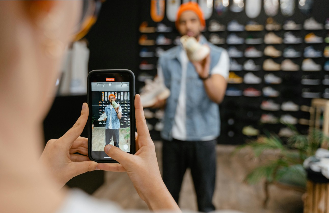 Verkaeufer eines Sneaker Stores vor der Cam