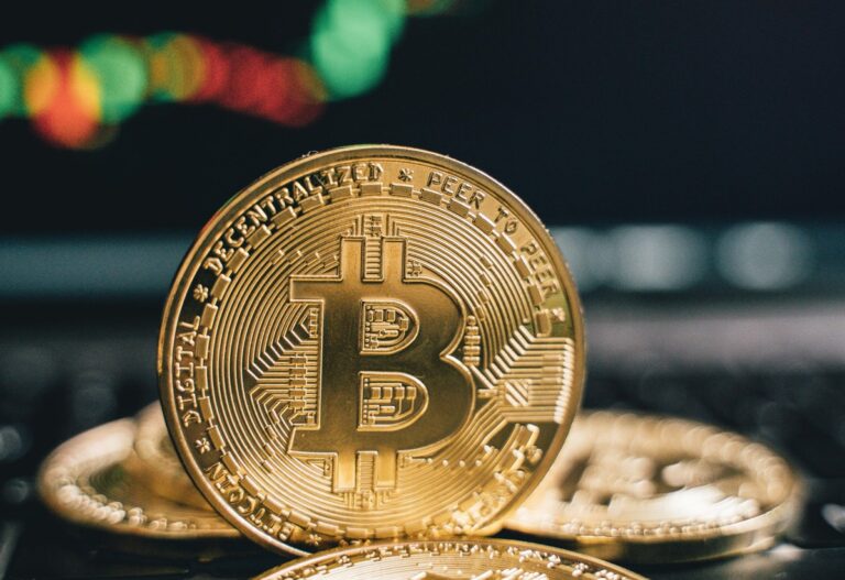Bitcoin Münze vor einem Börsenkurs
