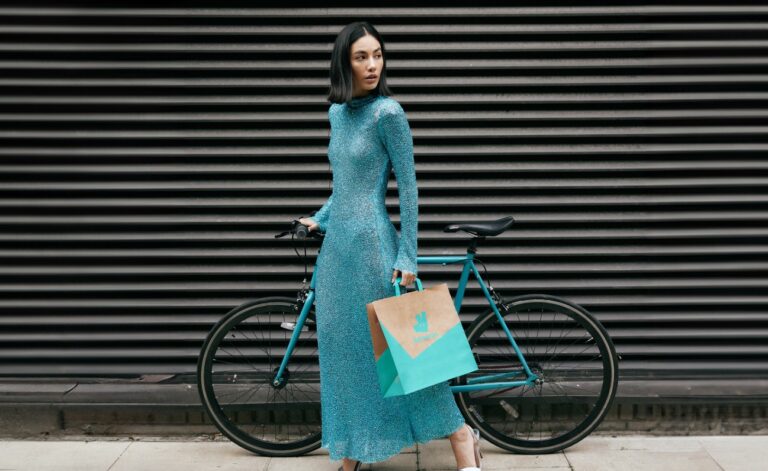 Model mit Fahrrad und Deliveroo Tuete