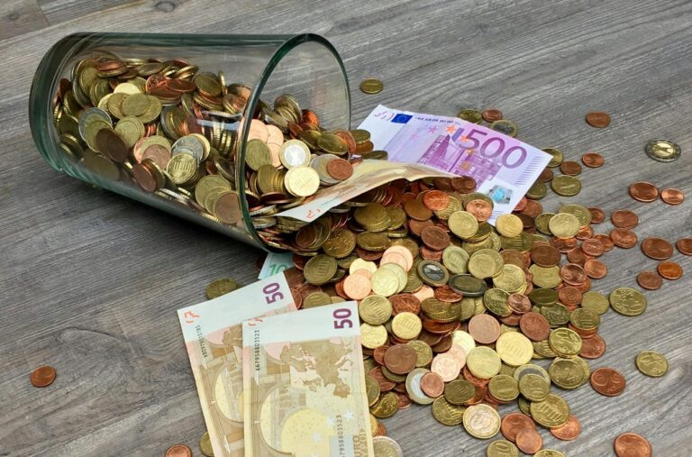 Glas mit Euro Geldscheinen und Muenzen