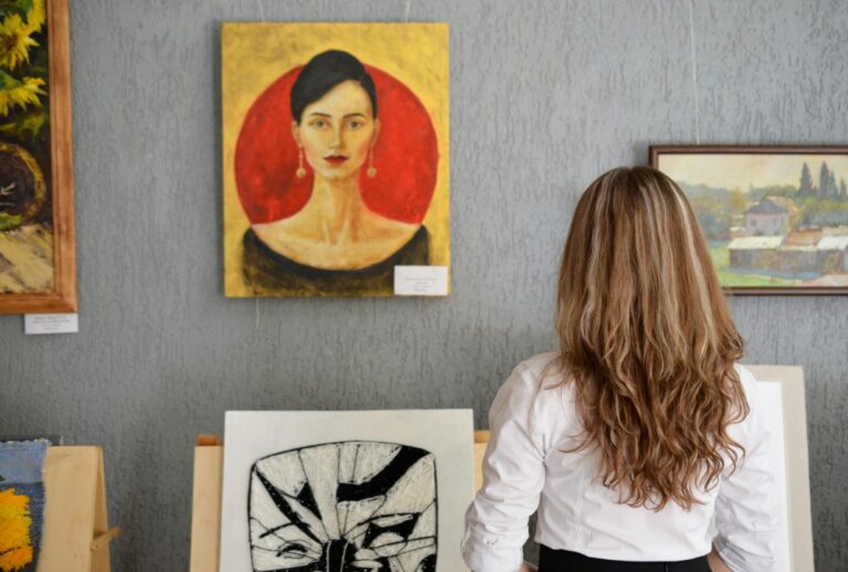 Frau vor mehreren Wandgemaelden