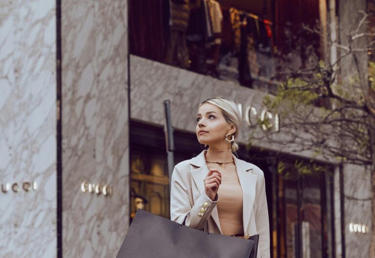 Frau mit Einkaufstuete vor Gucci Store