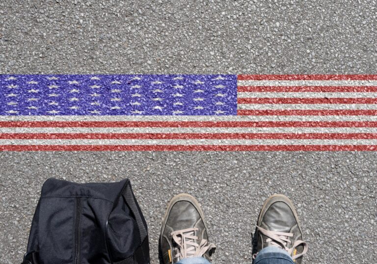Mann mit Rucksack vor USA Flagge