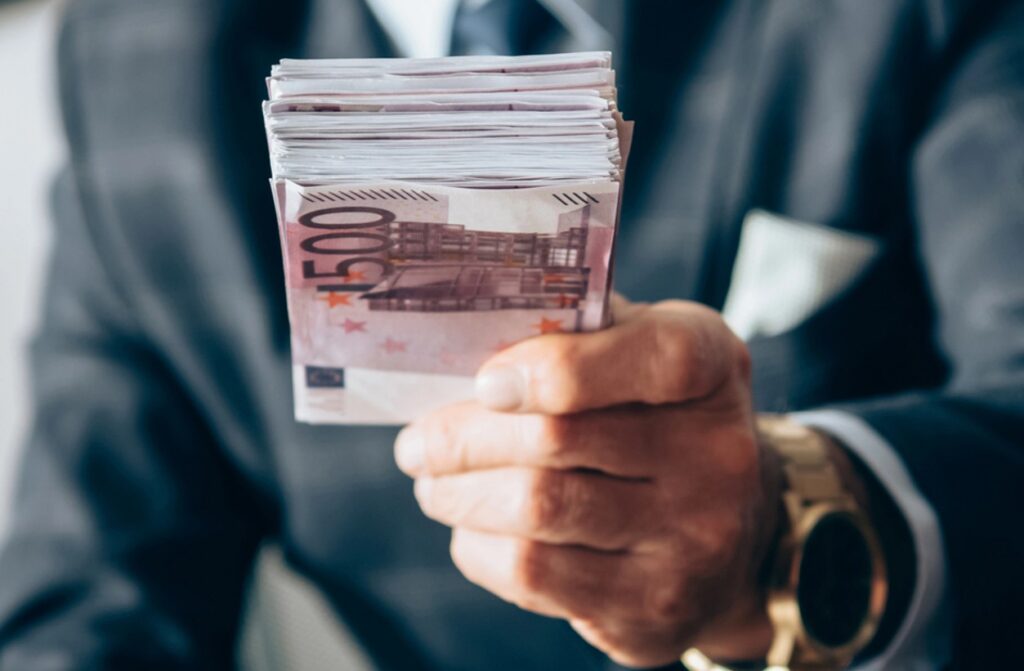 Geschaeftsmann mit Stapel 500 Euro Geldscheine