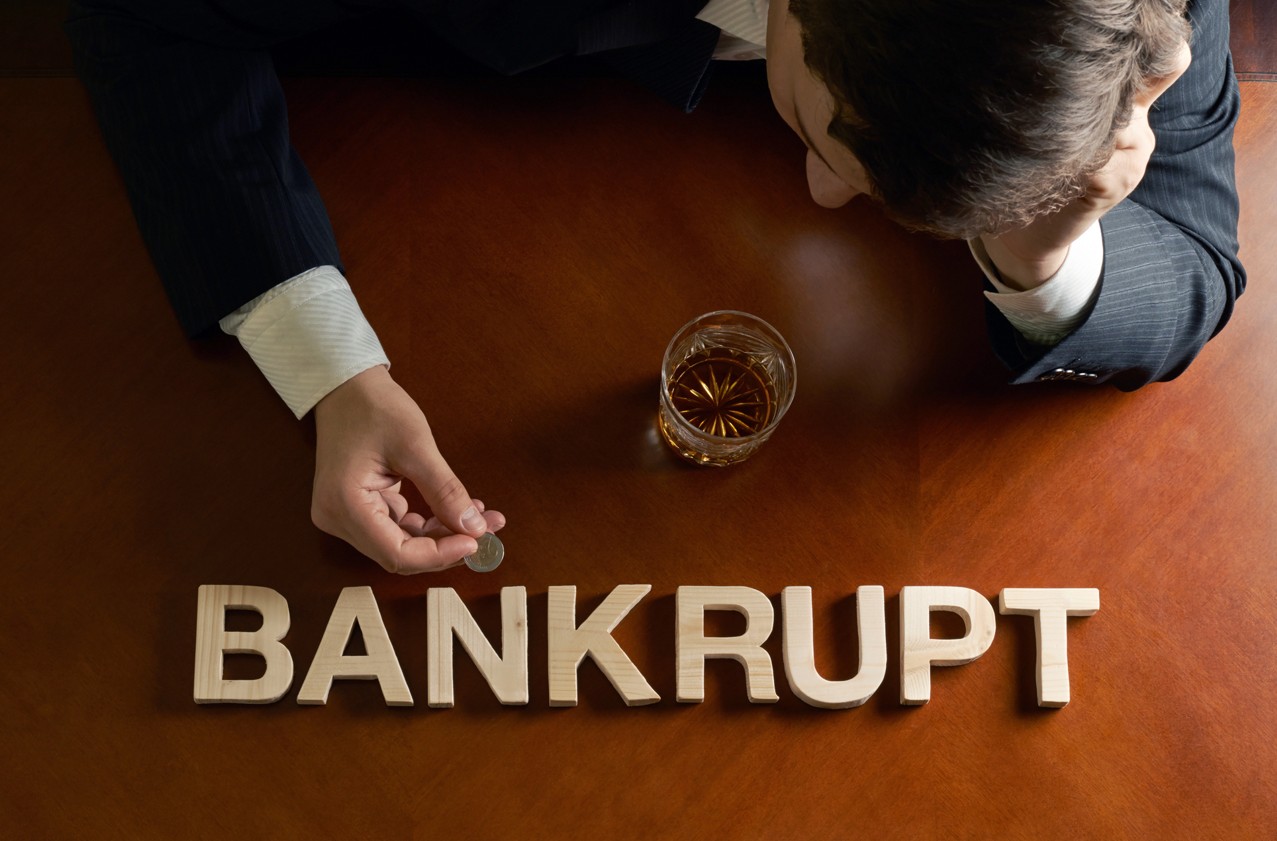 Bankrupt Schriftzug mit Symbolik zu Insolvenzen