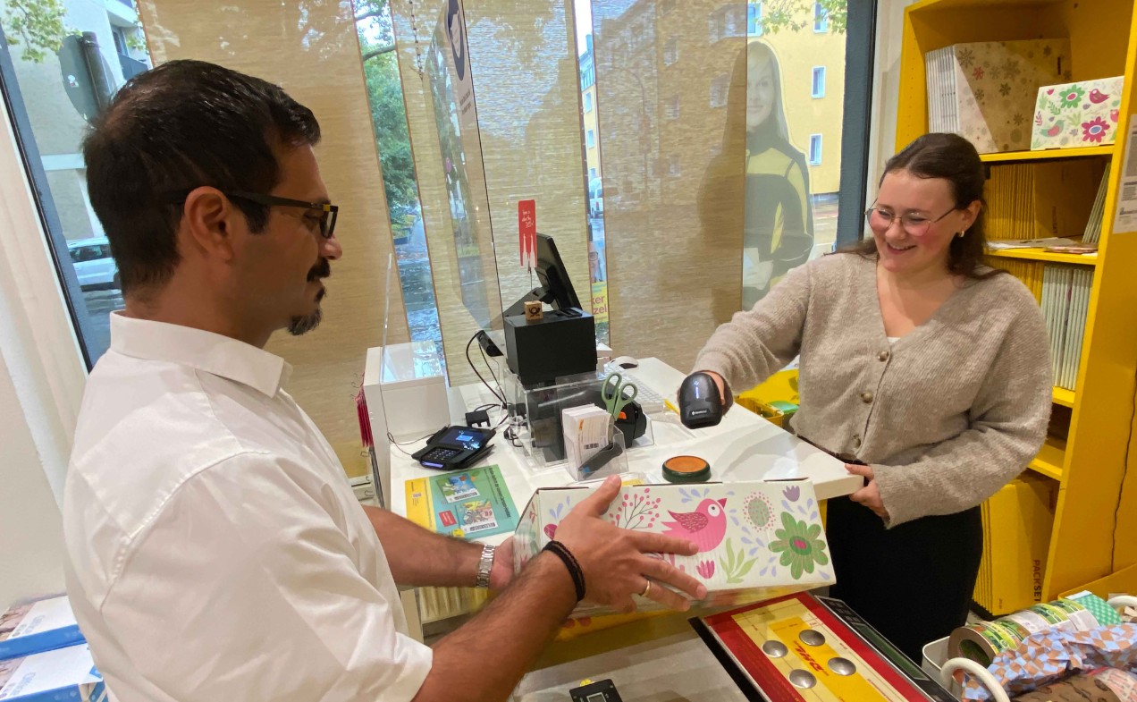 Kunde und Mitarbeiterin einer Post Partnerfiliale