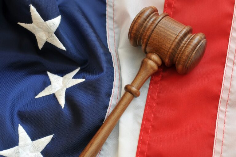 USA Flagge und Richterhammer als Symbol fuer US Gerichtsurteil