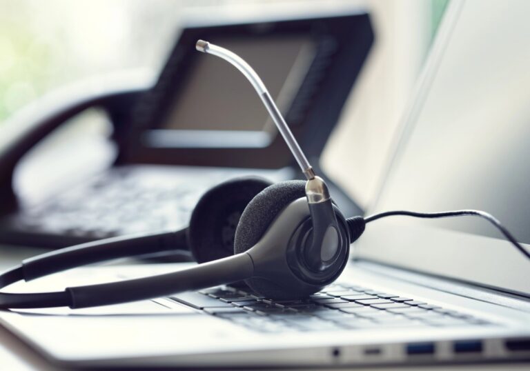 Headset vor einem Laptop und Telefon