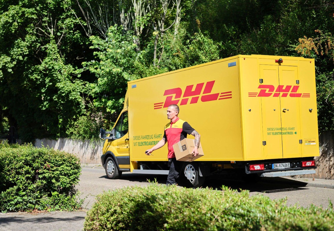 DHL Zusteller vor Lieferfahrzeug