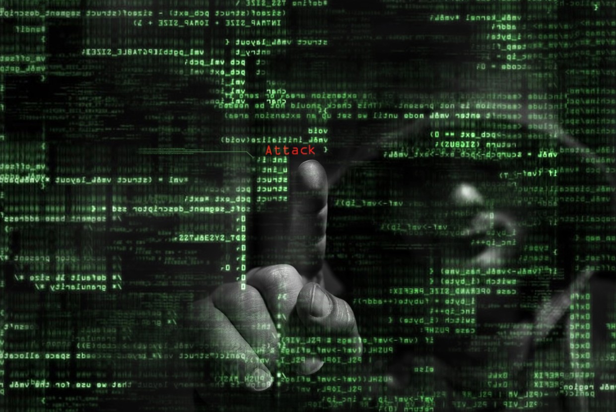 Hacker und Programmiercode als Symbol fuer Cyber Crime