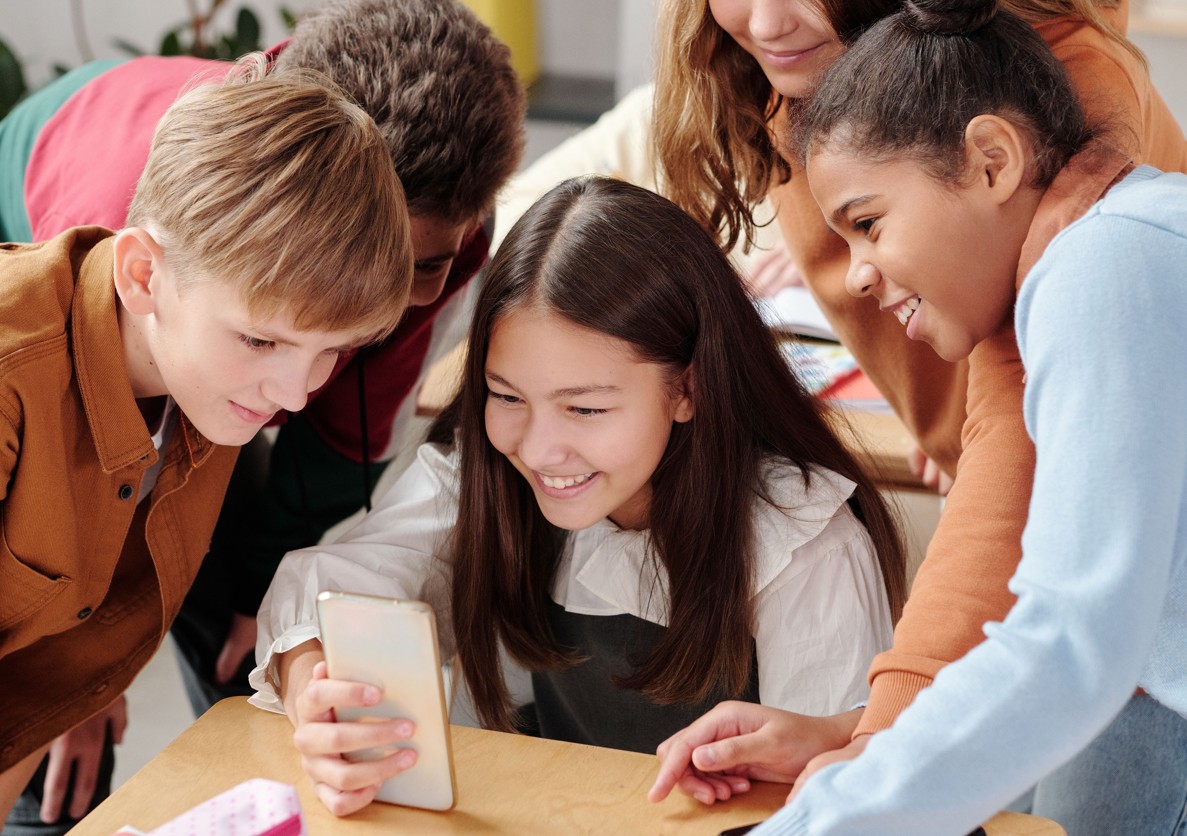 Junge Teenager um ein Smartphone stehend