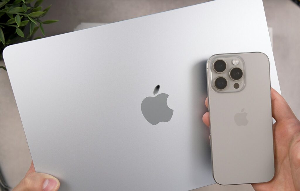 Mann mit Apple Laptop und iPhone
