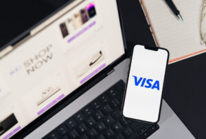 VISA Logo auf einem Smartphone vor einem Laptop
