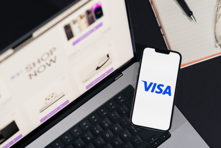VISA Logo auf einem Smartphone vor einem Laptop