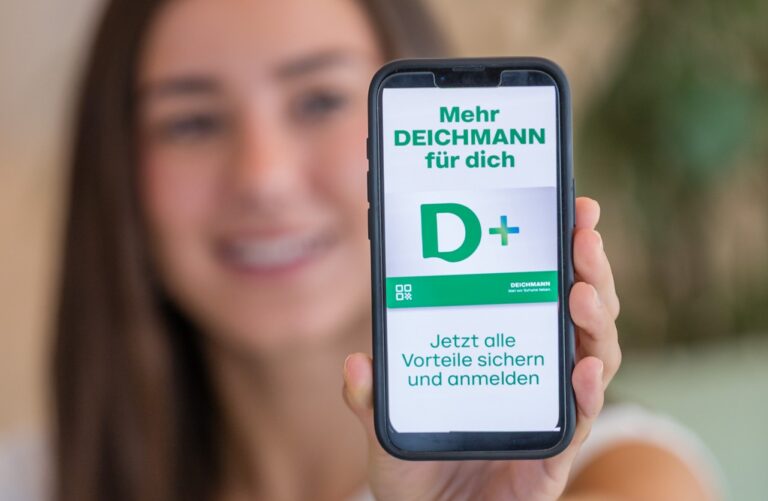 Junge Frau mit Smartphone und DEICHMANN PLUS App