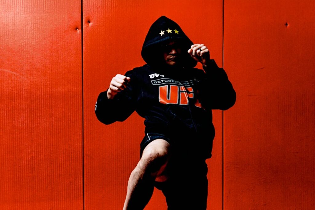 Mann mit OVO Hoodie vor roter Wand