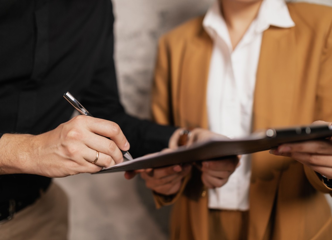 Mann und Frau bei einer Business Unterschrift