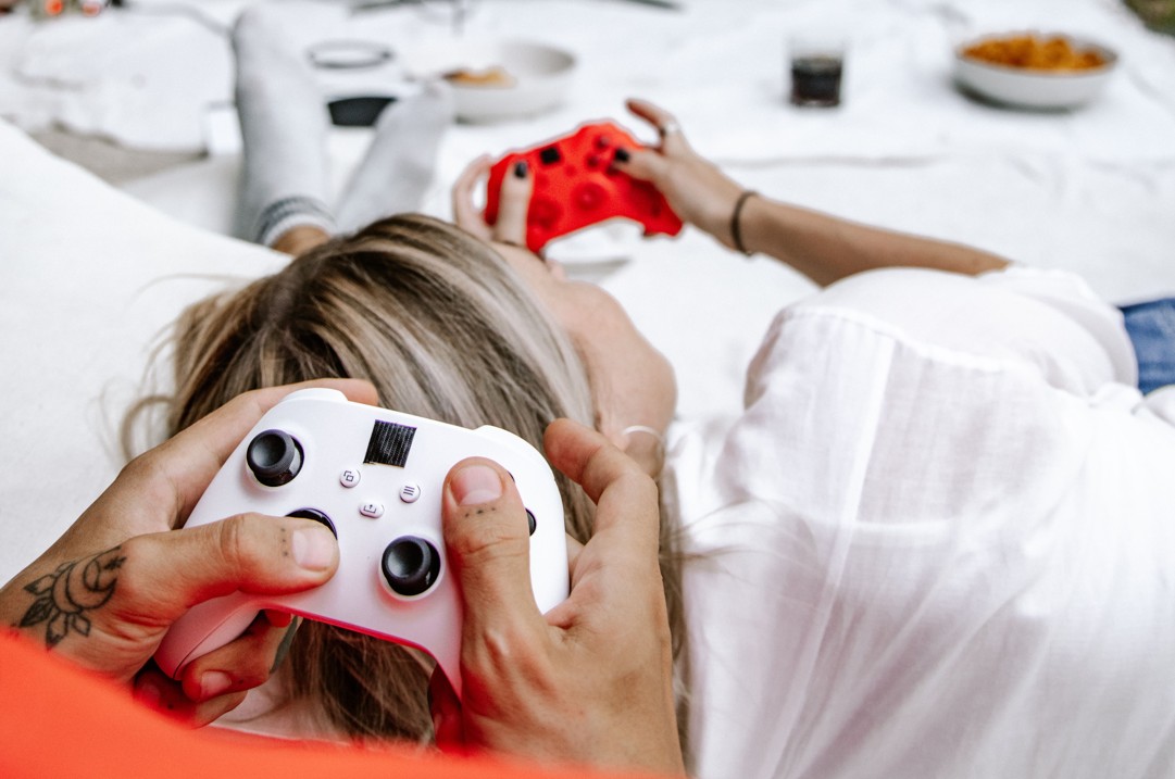 Paar beim gemeinsamen Gaming auf dem Sofa