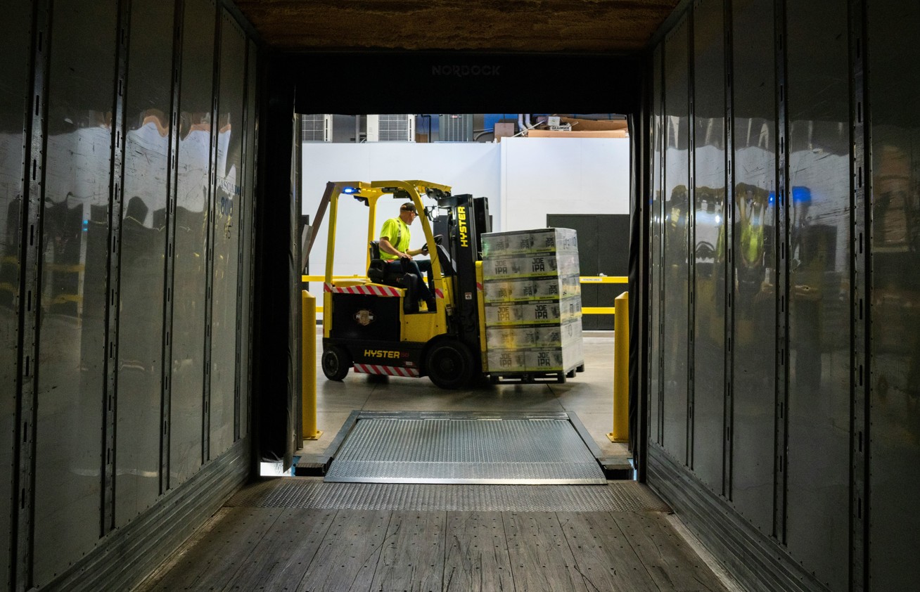 Arbeiter mit Gabelstapler bei LKW Beladung