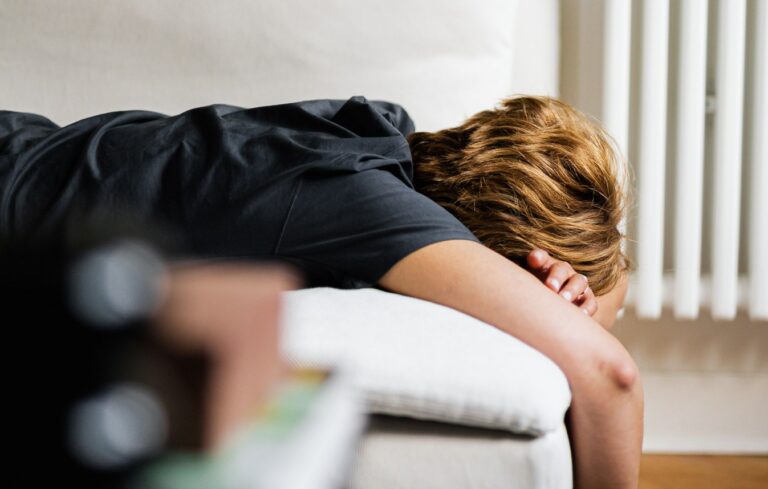 Junger Mann liegend auf einer Couch