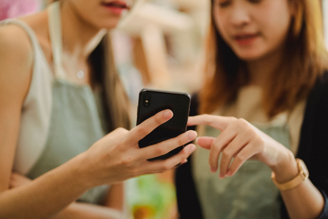 Zwei chinesische jungen Frauen mit Smartphone