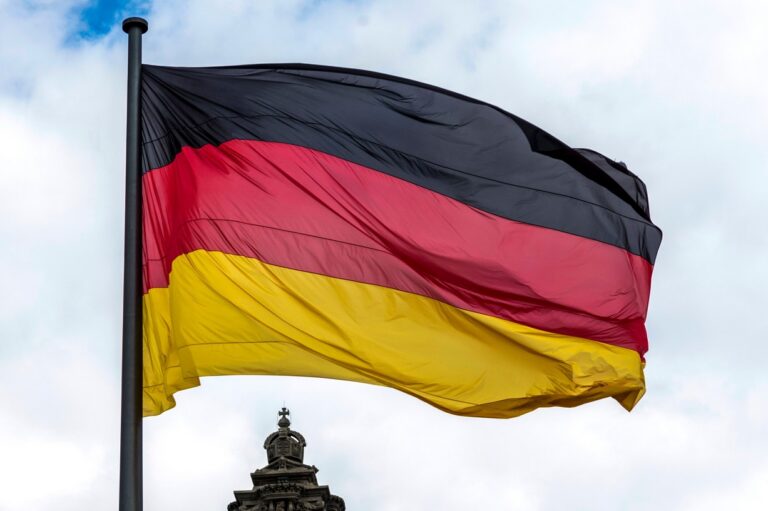 Deutsche Flagge vor bewoelktem Himmel