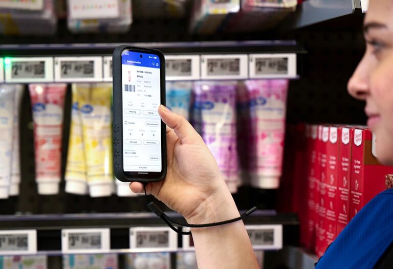 Kundin mit Walmart App vor digitalen Preisschildern