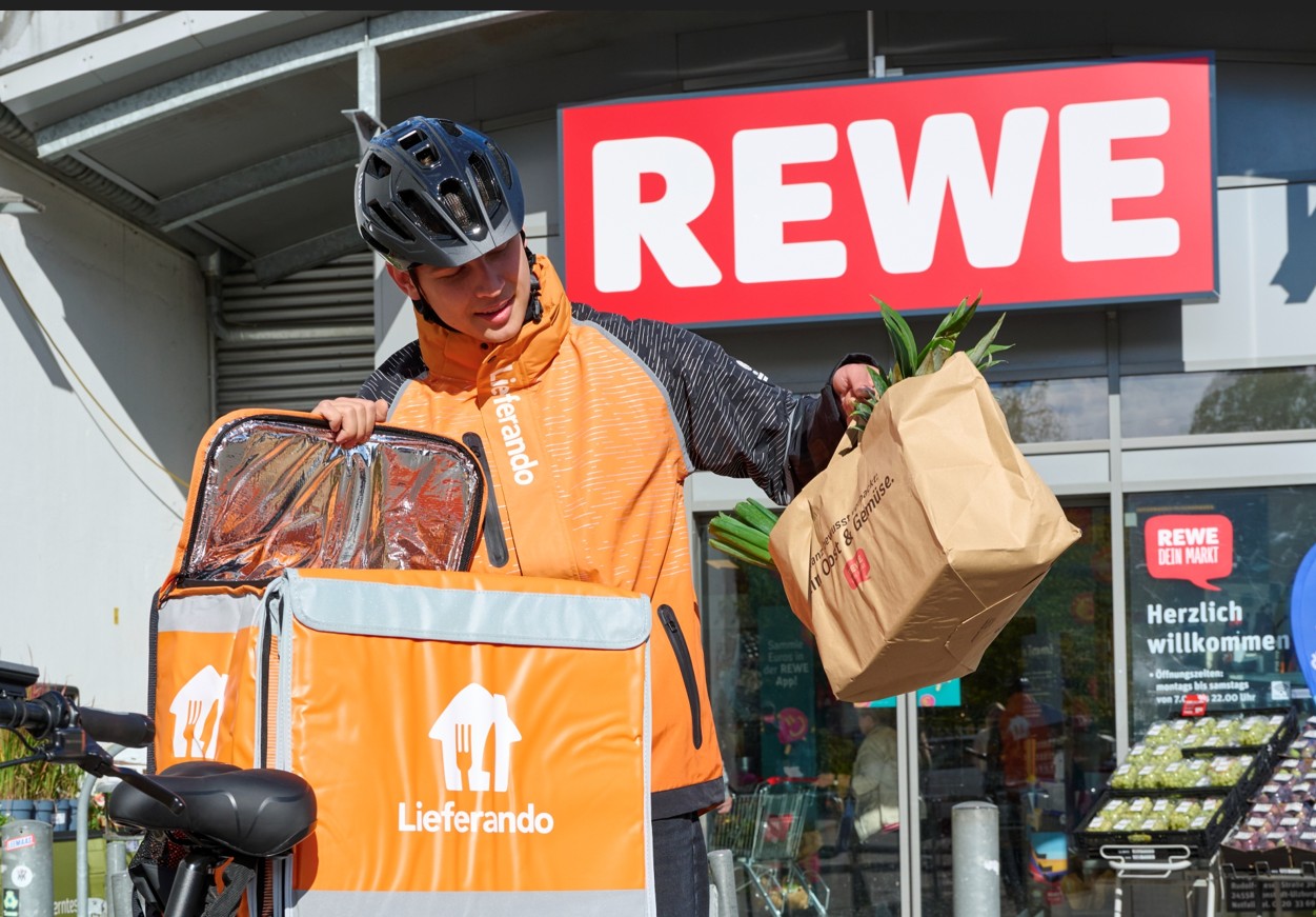 Lieferando Fahrer bei Abholung von REWE Lebensmitteln