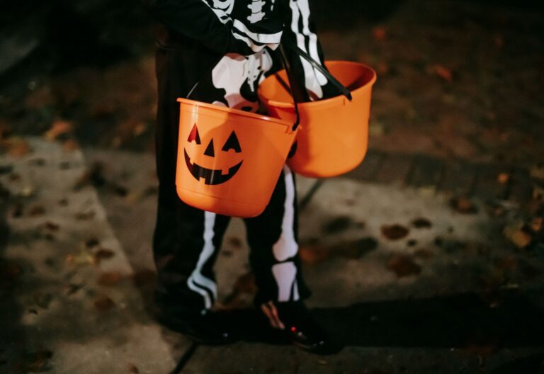Verkleidetes Kind mit Halloween Eimern mit Sweets