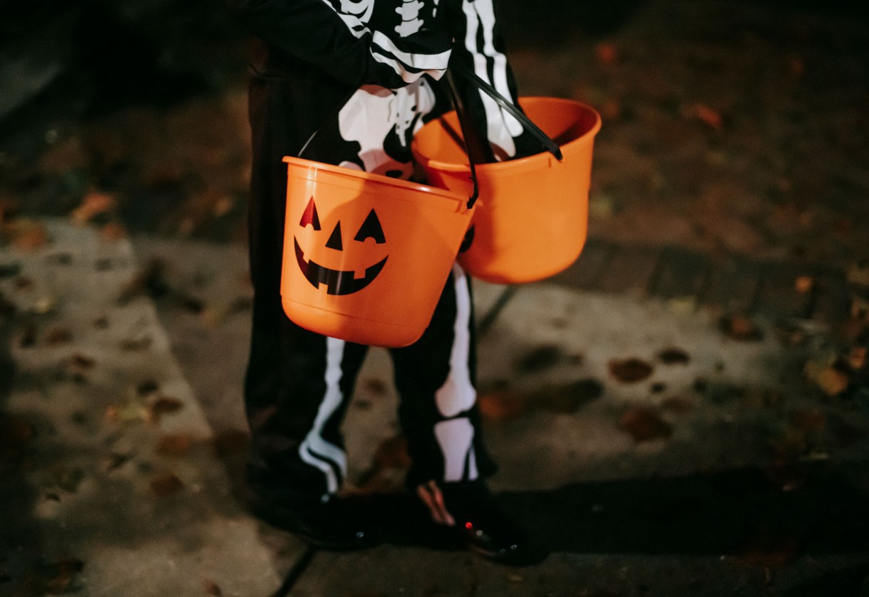 Verkleidetes Kind mit Halloween Eimern mit Sweets